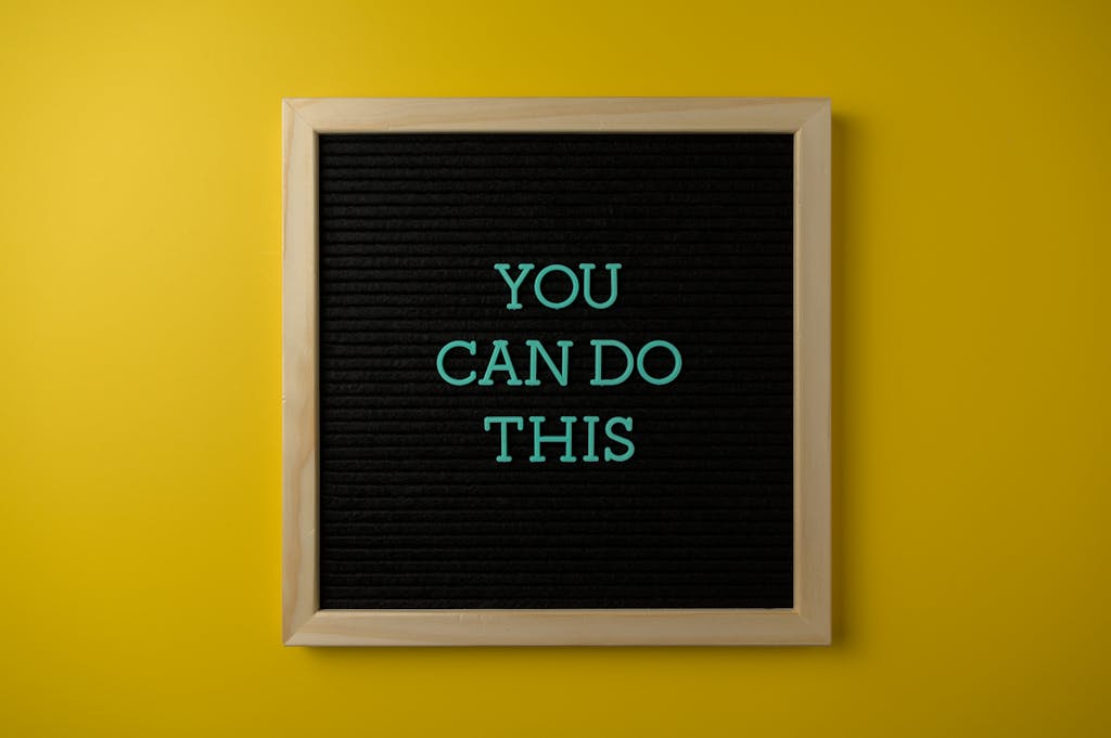 Framed Board with a Motivational Slogan on a Yellow Wall