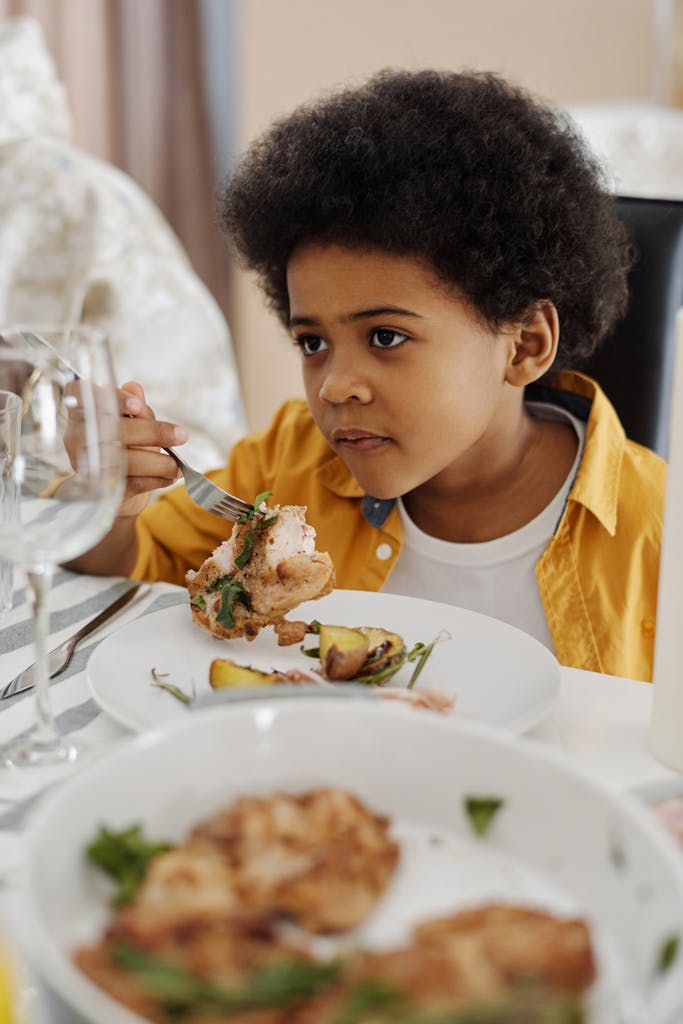 Boy Sitting at a Table with chicken on his Plate -Breakfast Swaps Kids Will Love