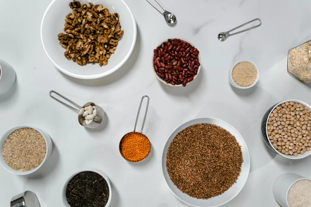 Flat lay of nuts, grains, and beans artfully arranged on a marble countertop.