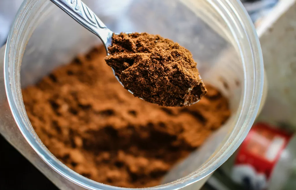 pexels-photo-1212845-1212845 Focused shot of a spoon scooping cocoa powder from a container, emphasizing texture.