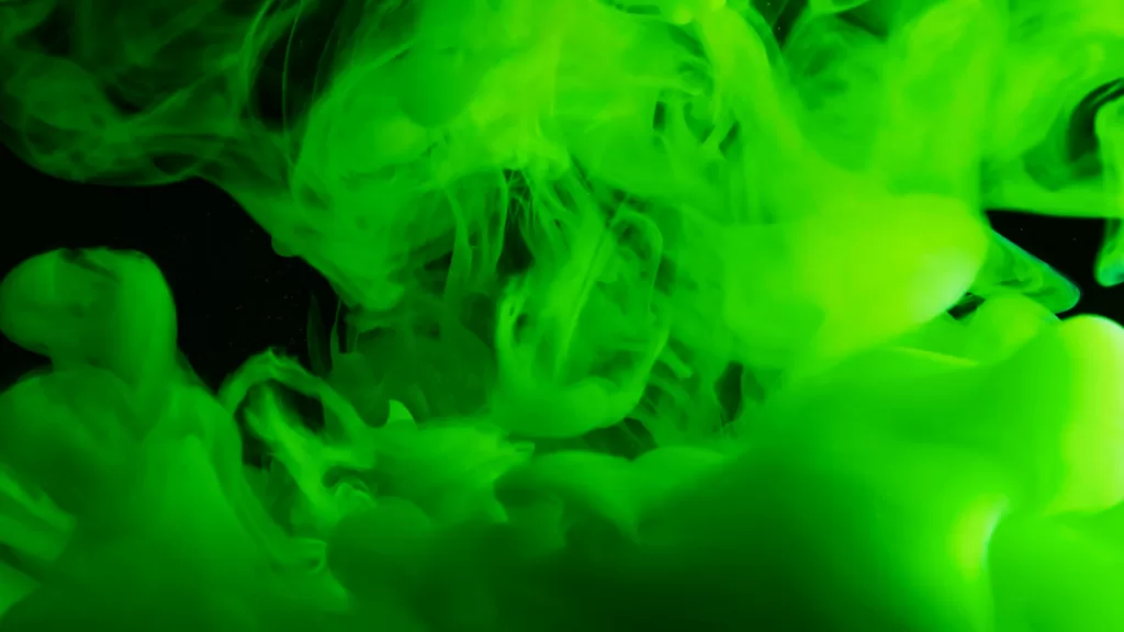 Vivid green ink swirling in liquid creates a mesmerizing abstract texture.